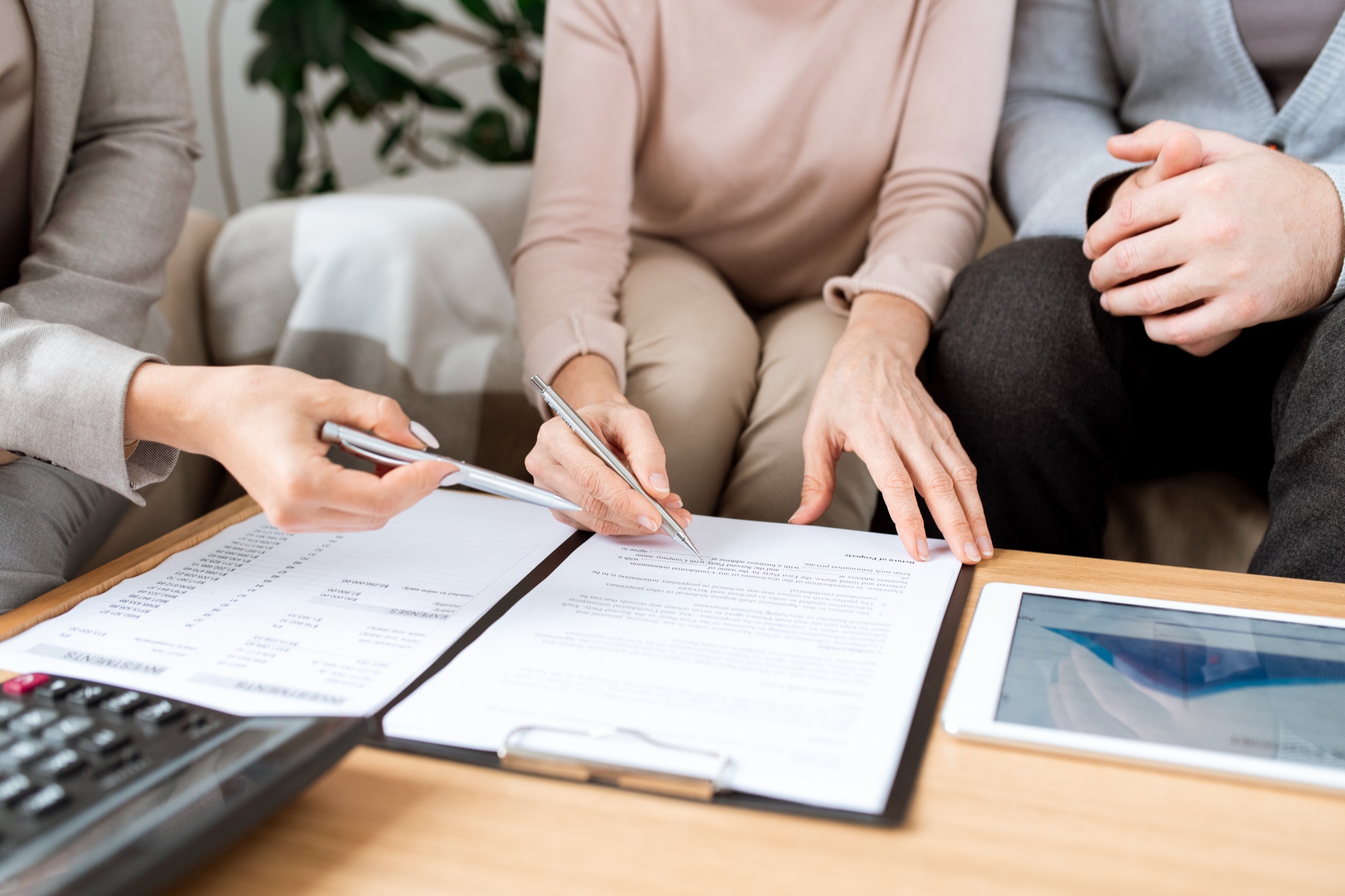 An advisor reviewing estate and financial documents with a couple at a table.
